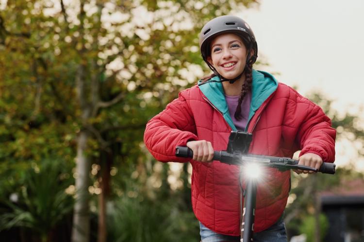Mädchen fährt E-Scooter.